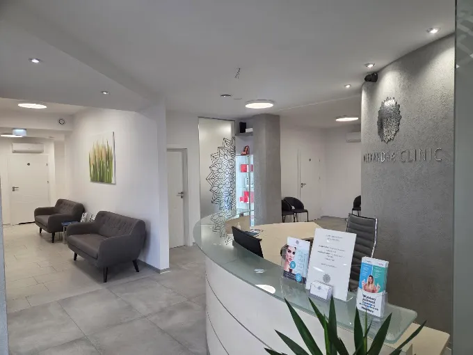 Recepcja Alexandra Clinic jasne wnętrze z ladą recepcyjną, poczekalnią i fotelami dla pacjentów.